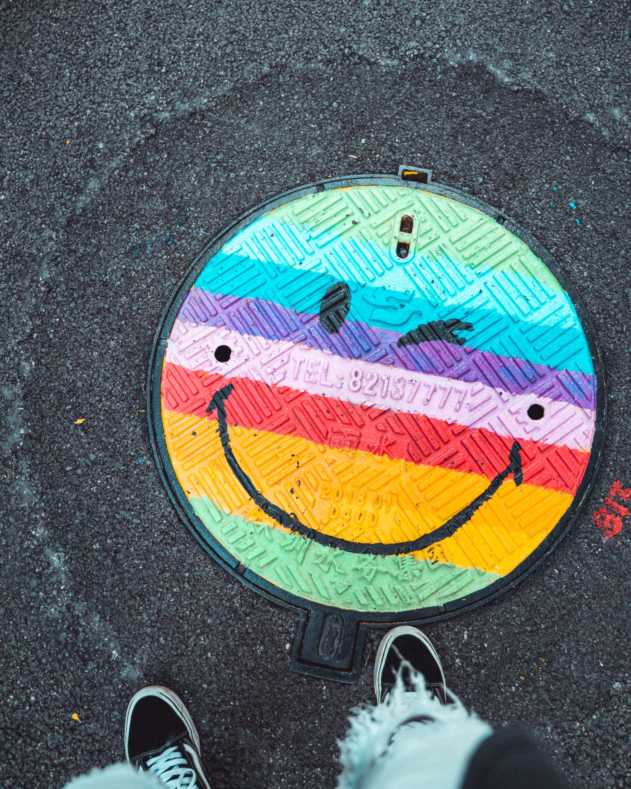 Smiley face emoji painted on a manhole cover